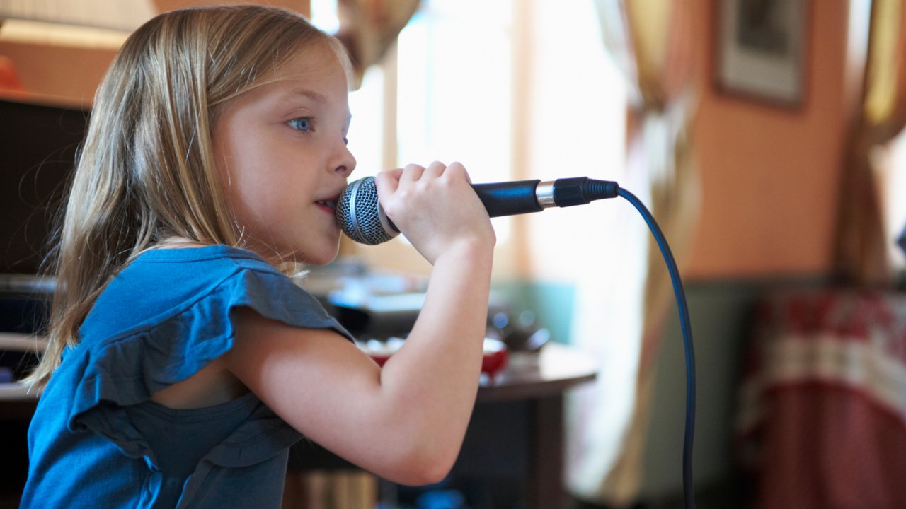 A young student singing into a microphone